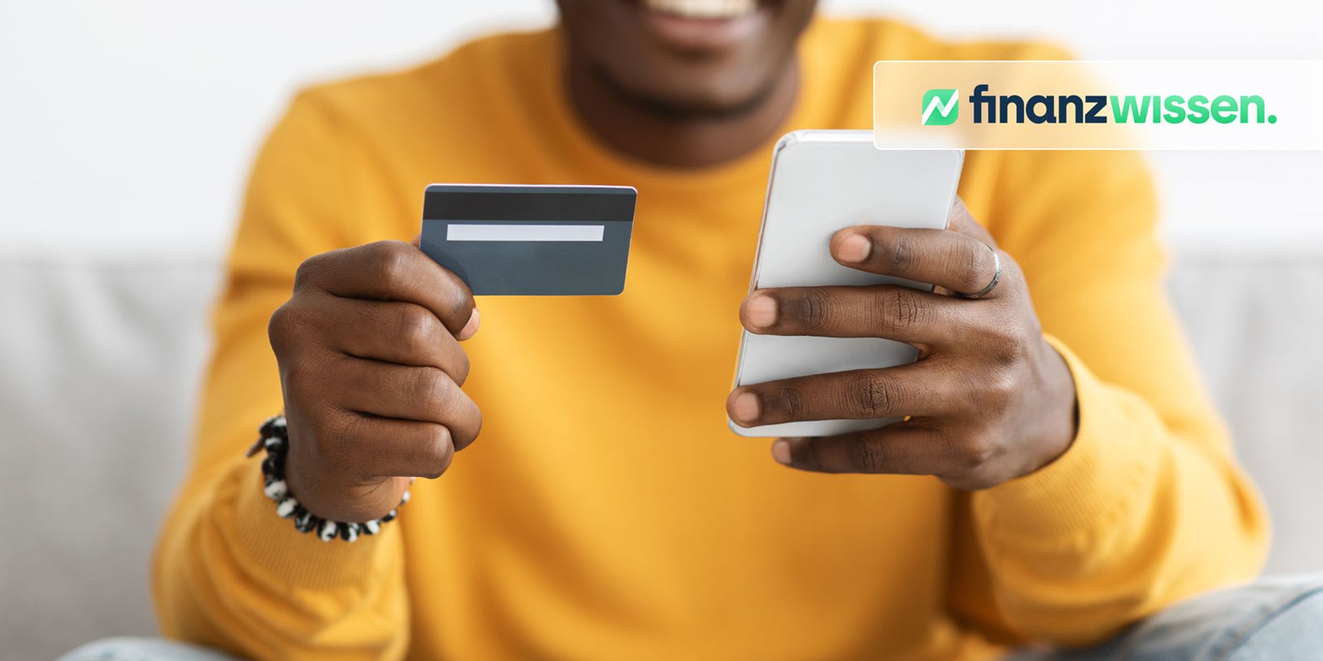 Junger Mann, der durch einen Konsumkredit mit Kreditkarte Dinge kauft