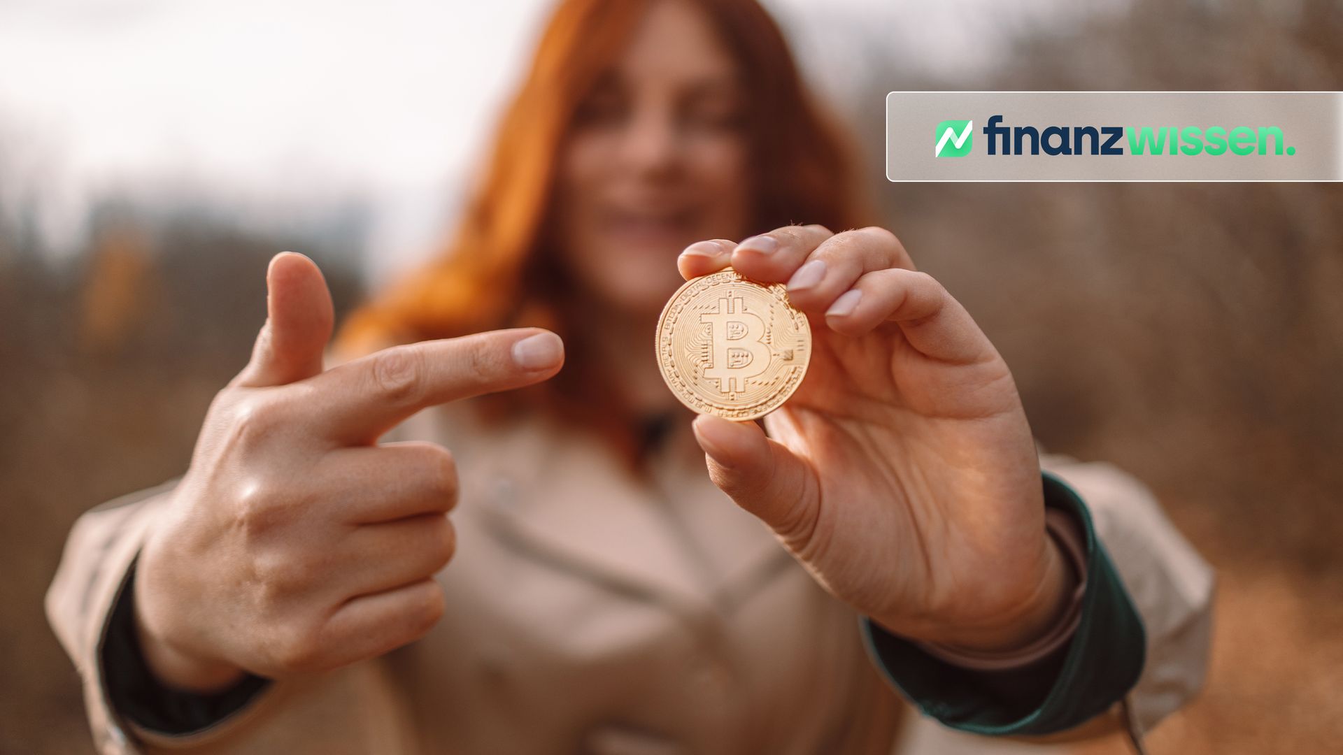 Frau hält vergoldete Bitcoin Münze fest