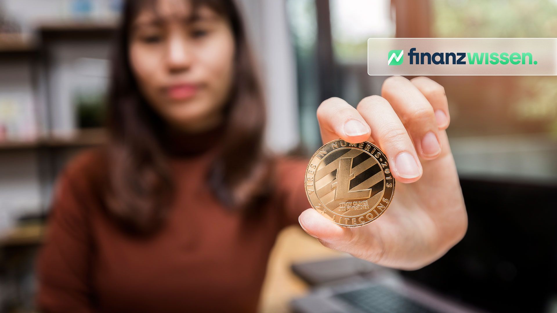 Frau hält symbolischen litecoin in der Hand