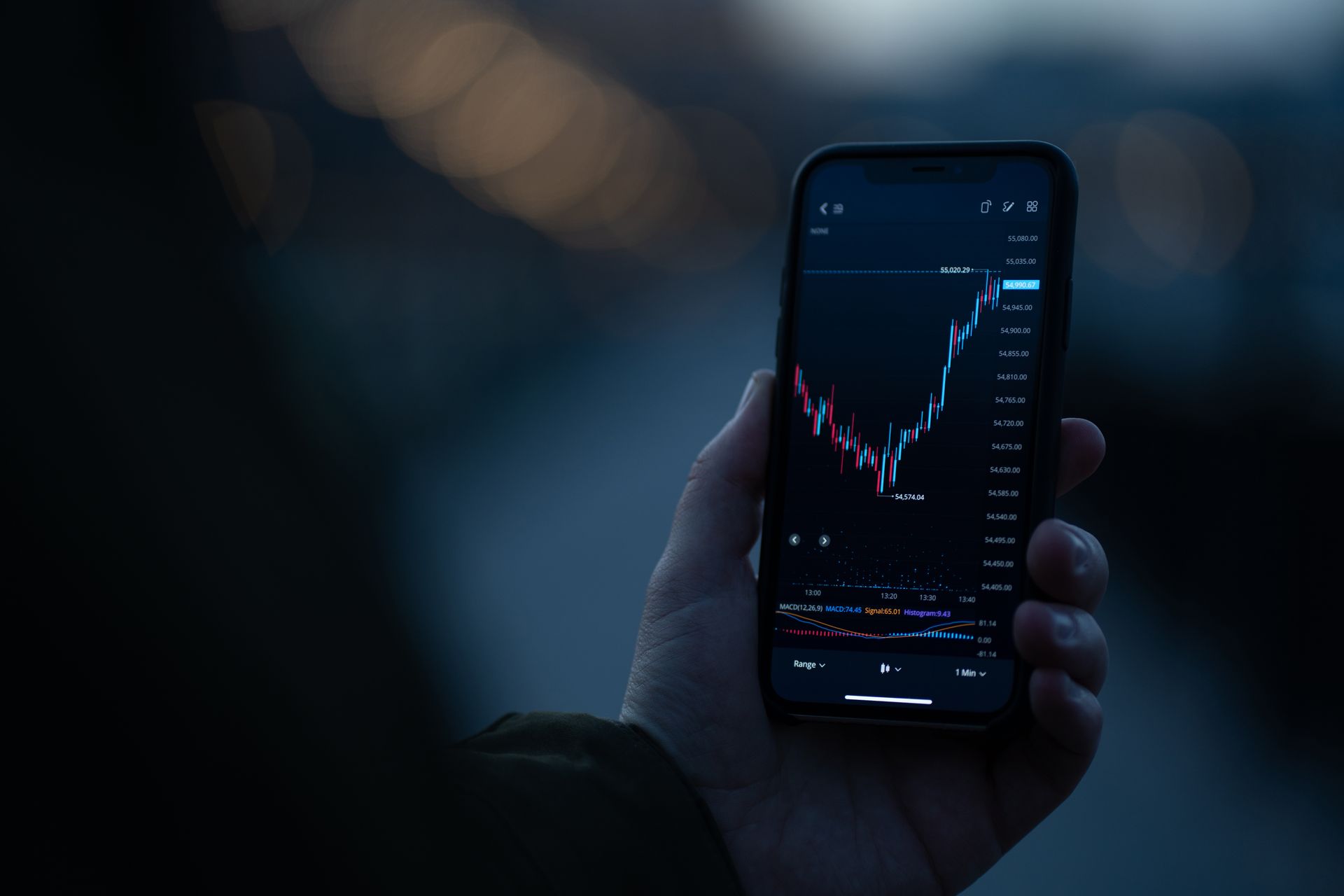 Trader hält ein Handy mit Aktien-Chart