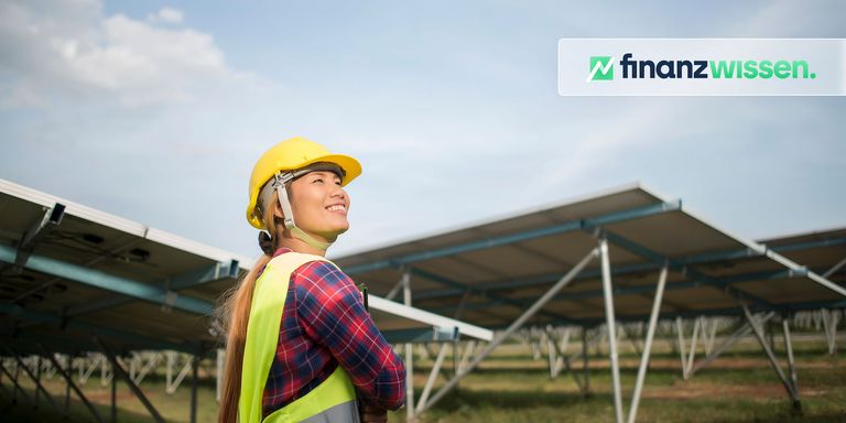 Frau steht vor Solarfeldern und investiert in Solaraktien