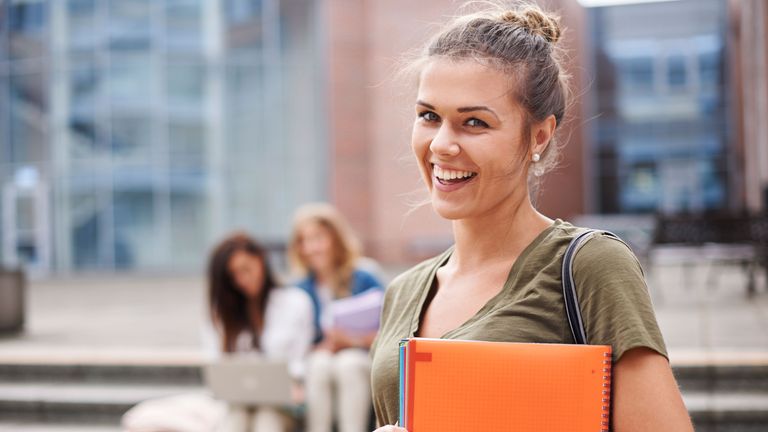 Lachende Studentin auf einem Universitäts-Campus