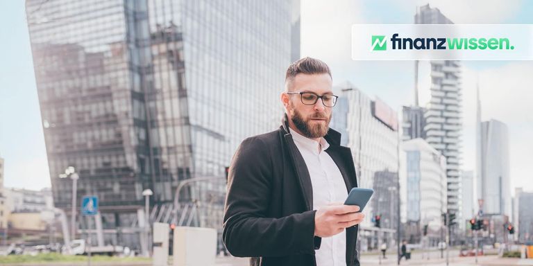 Junger Bänker überprüft Aktienkurse am Handy