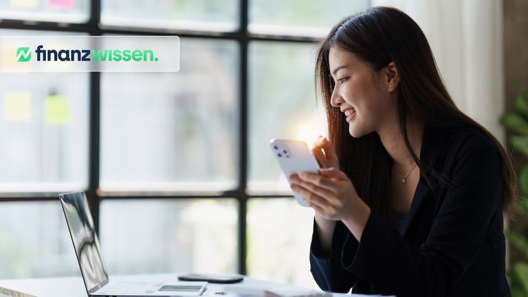 Aktien Investorin überprüft ihr Portfolio am Laptop und Handy.