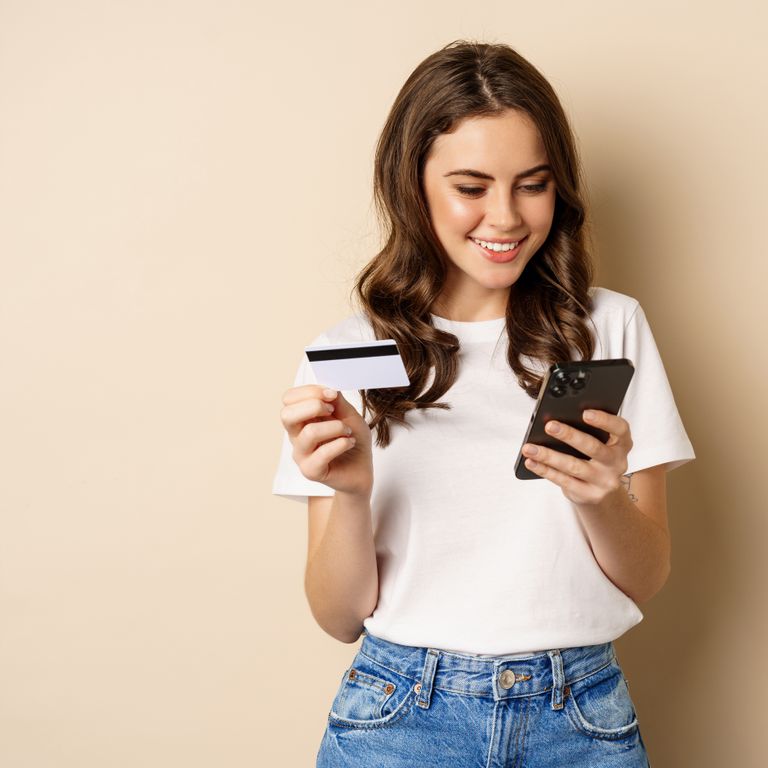 Junge Frau mit Kreditkarte und Smartphone