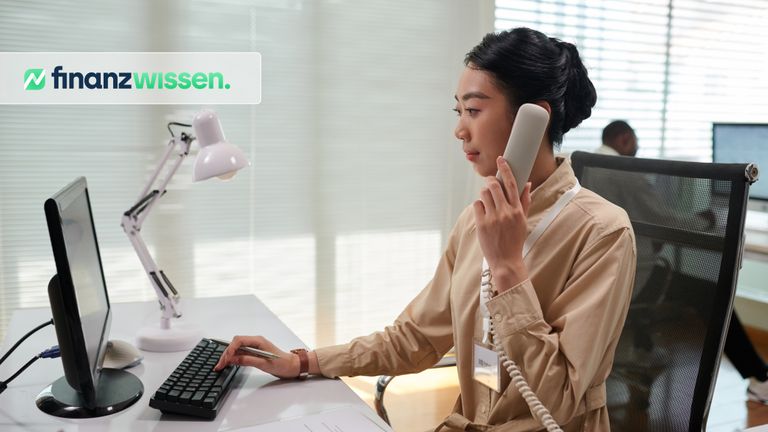 Junge Bankangestellte prüft eine telefonische Order eines Vanguard ETF
