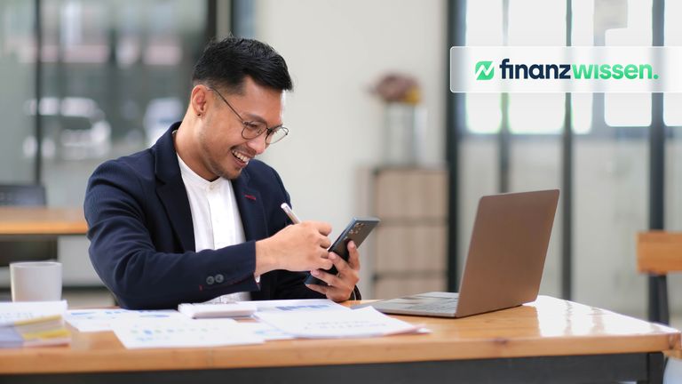 Junger Anleger prüft auf seinem Smartphone die Ertragsverwendung von ETFs