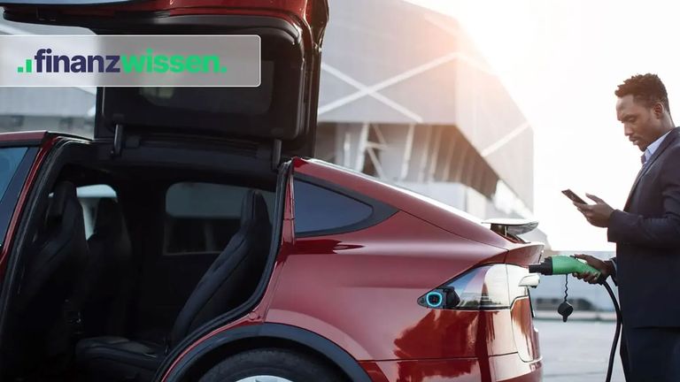Mann lädt seinen Tesla als Sinnbild für Autoaktien