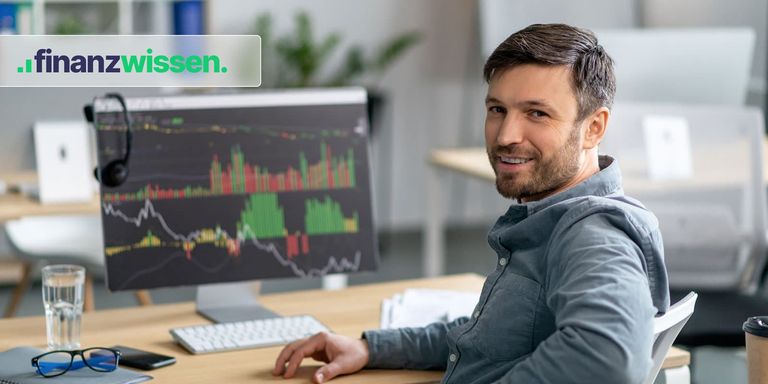 Trader arbeitet mit technischen Analyse-Tools am PC und blickt über die Schulter in die Kamera