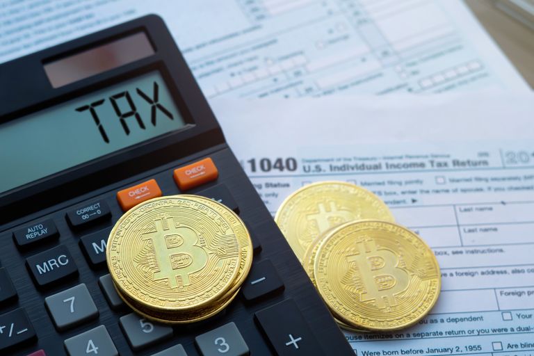 Bitcoin Münzen und ein Taschenrechner auf dem Tax steht