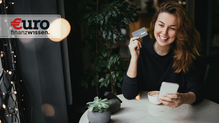 Junge Frau bezahlt mit Girocard im Cafe